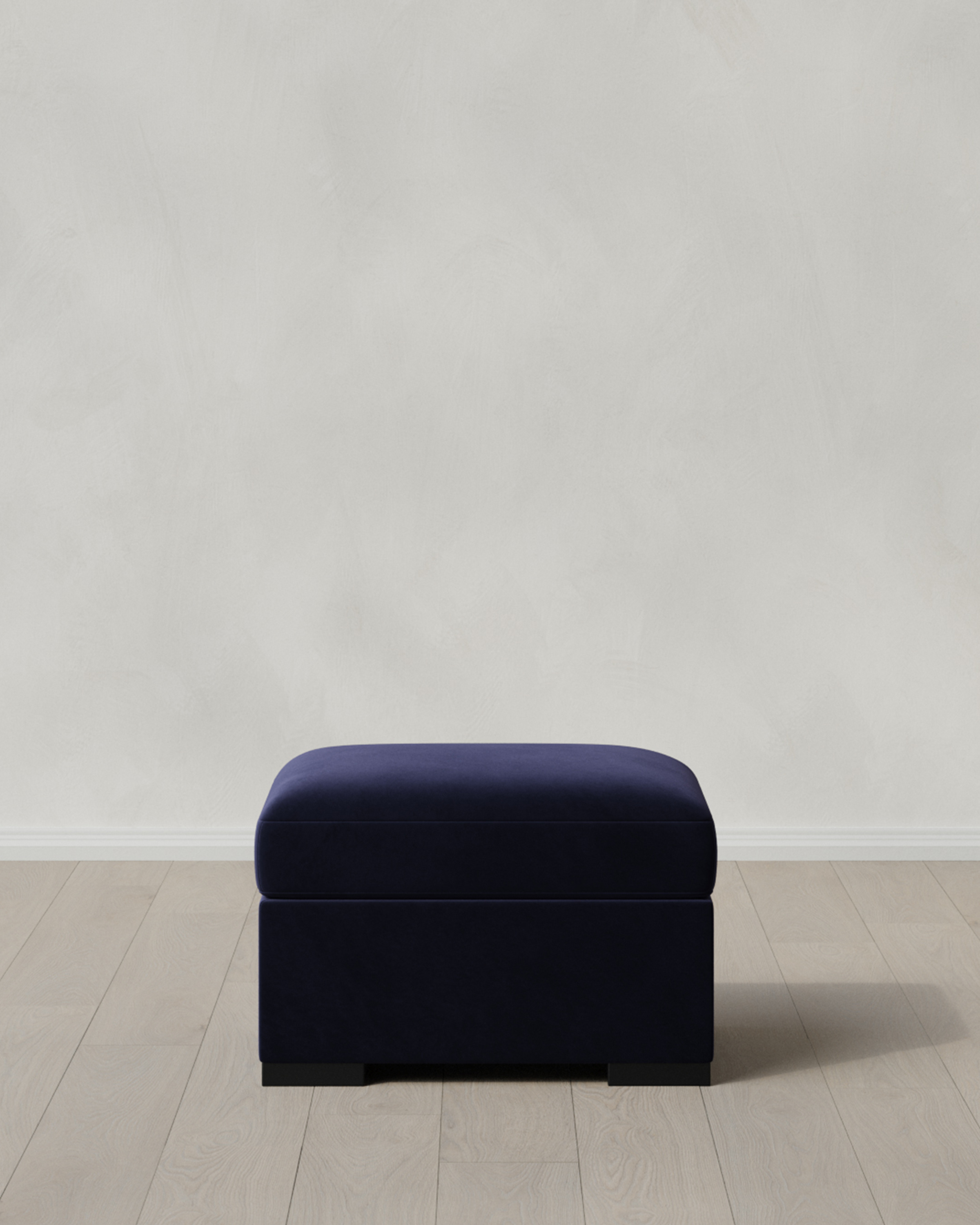 Dark navy blue ottoman on a light floor.