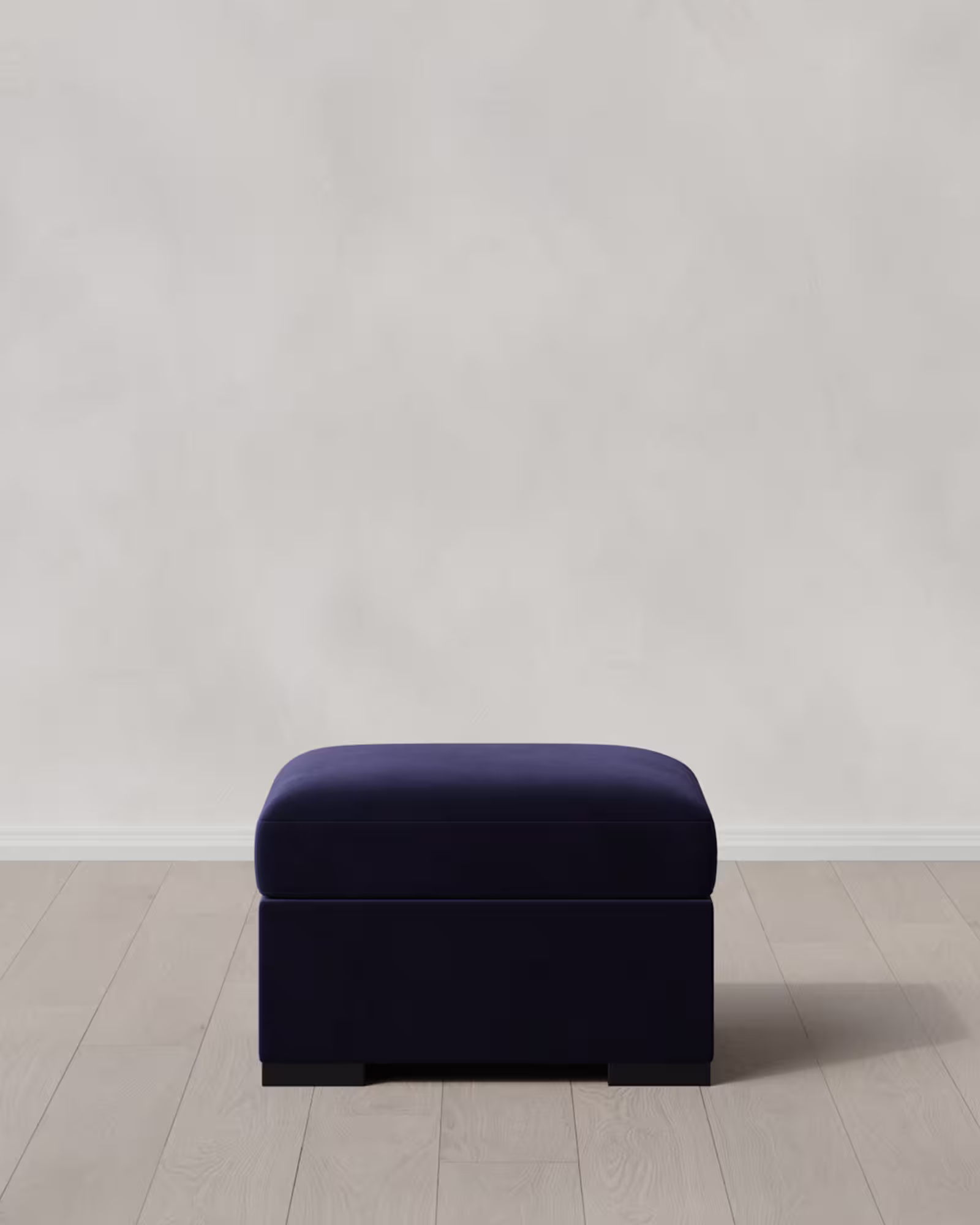 Dark navy blue ottoman on a light floor.