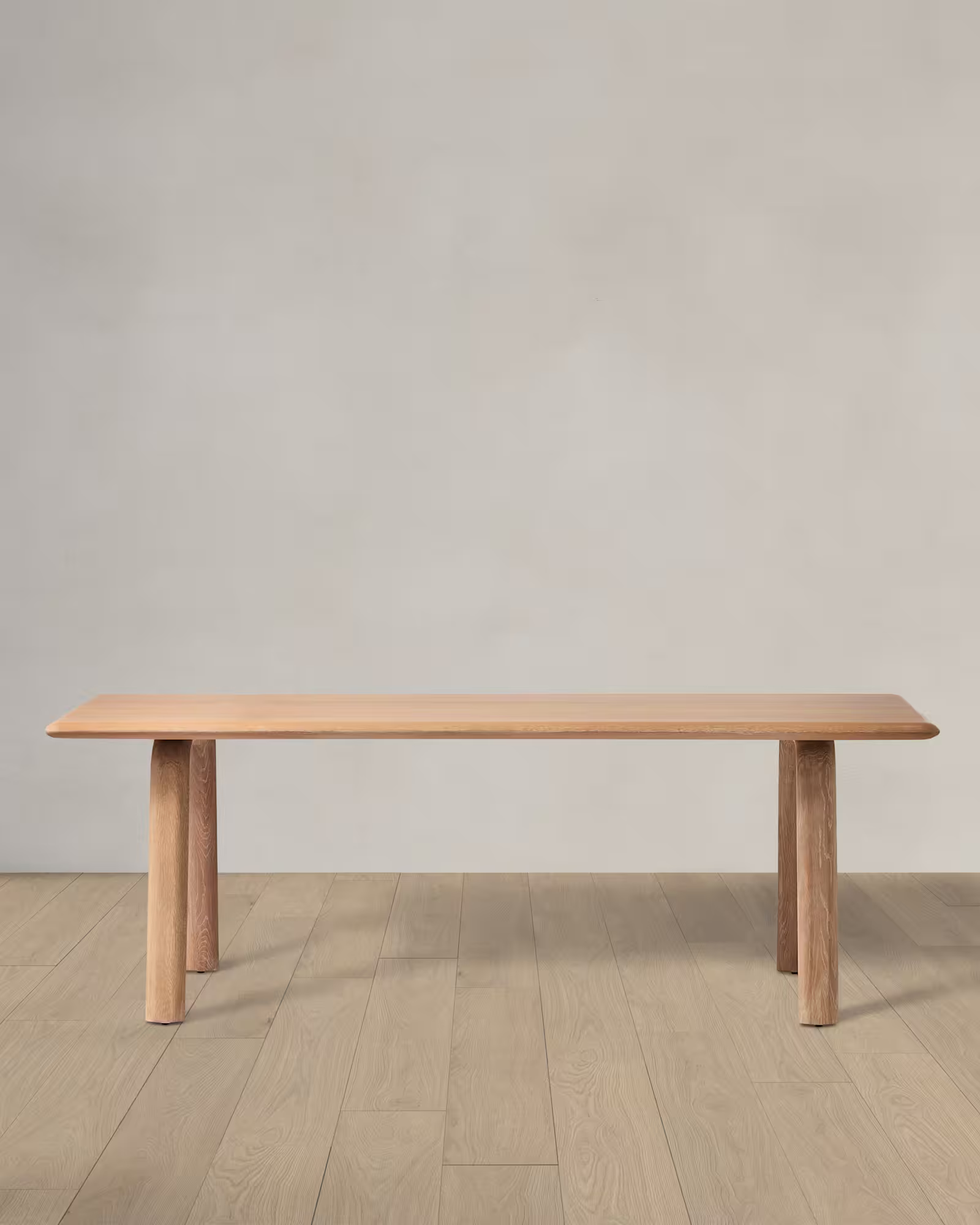 Solid wood dining table with natural oak finish on a light wooden floor.
