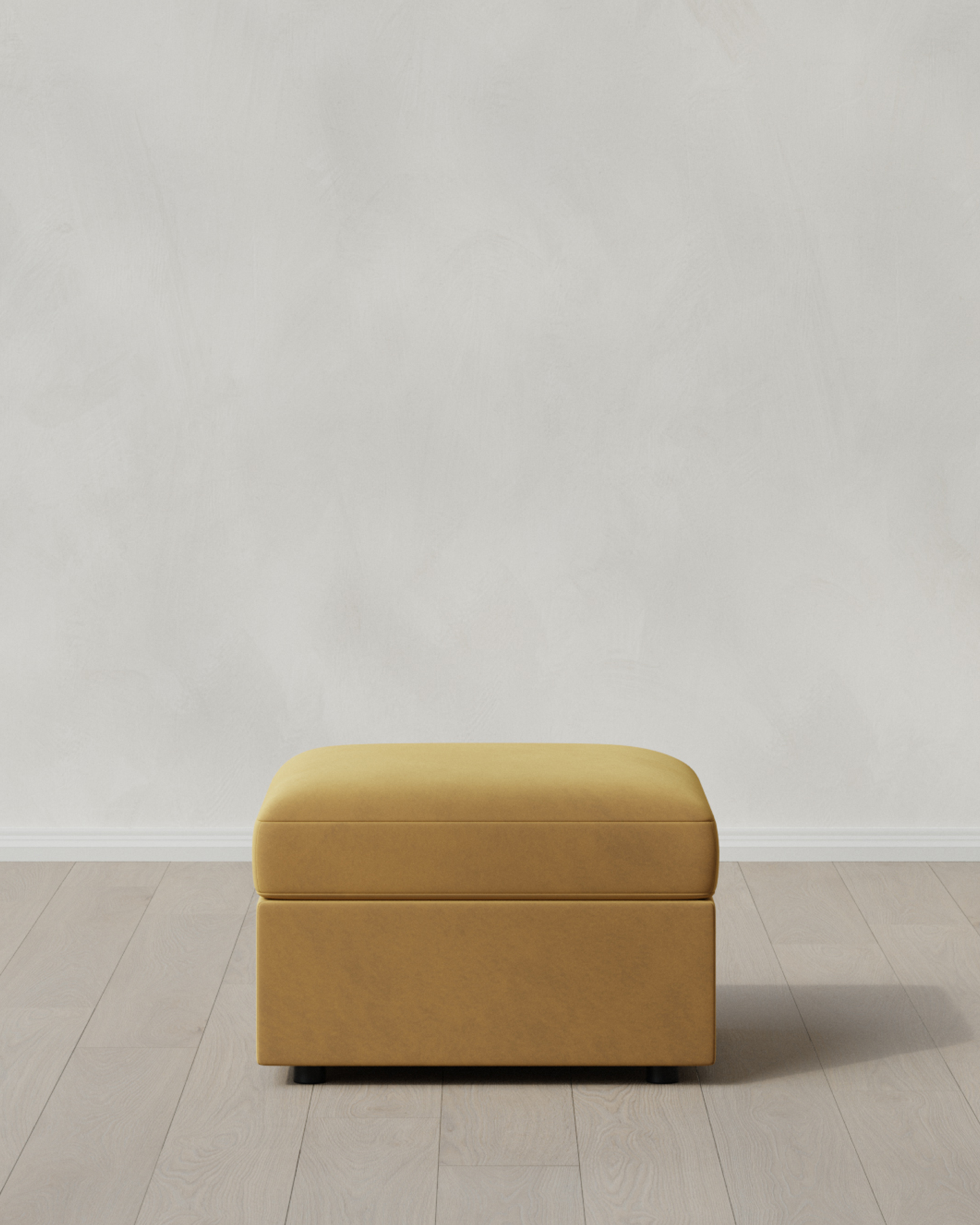 Caramel colored ottoman on a light floor.