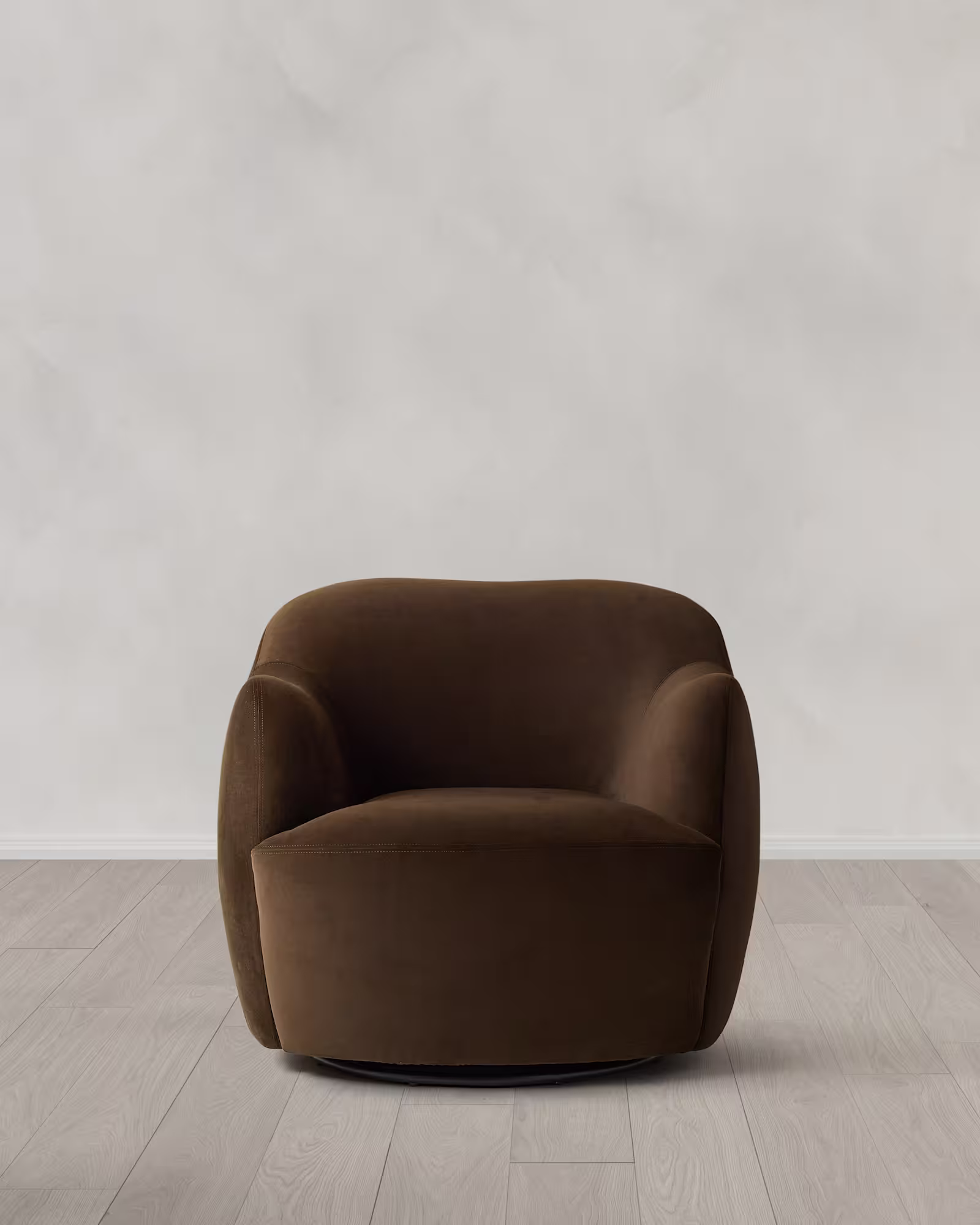 Brown curved accent chair on a light wood floor.