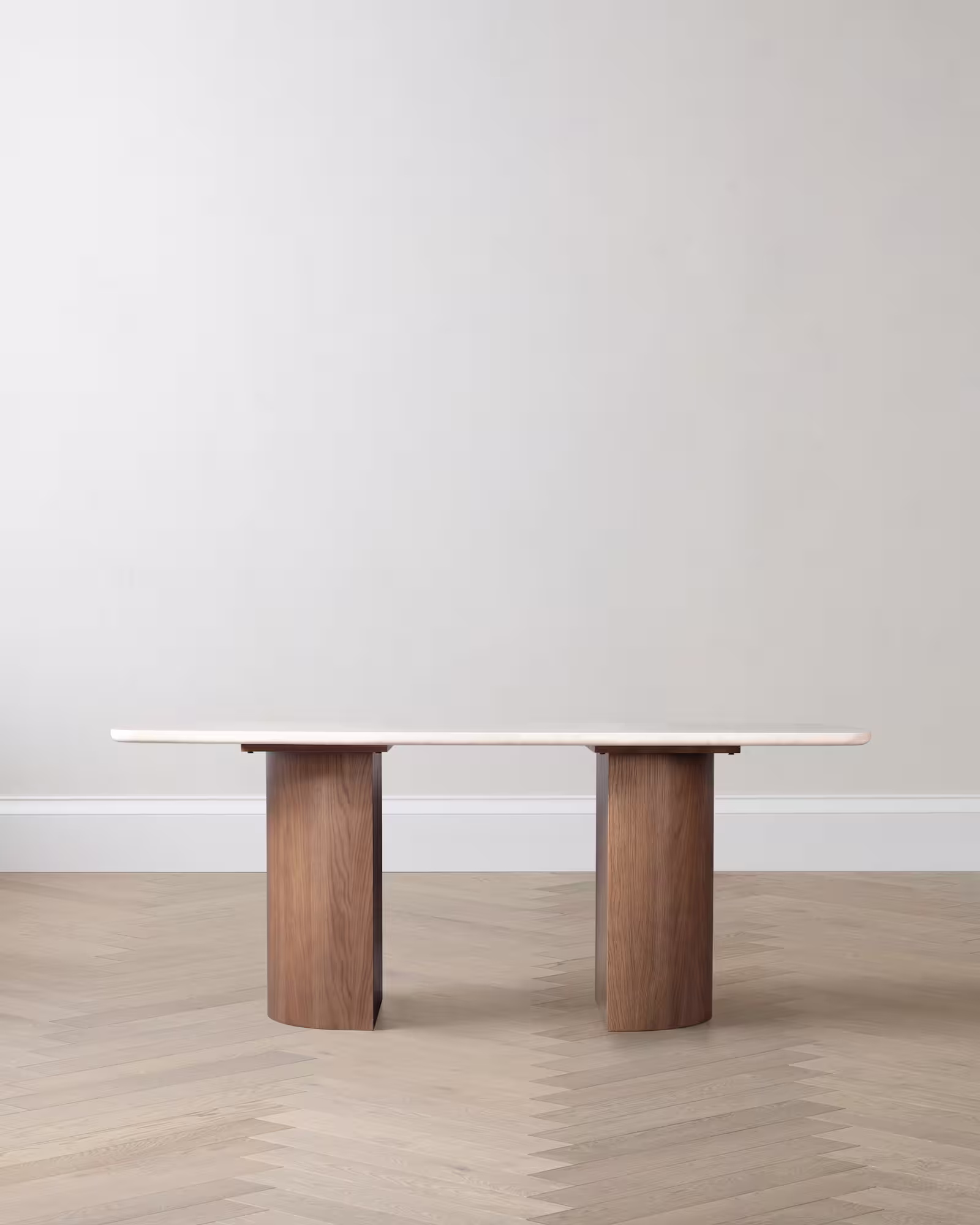 Marble dining table with wooden pedestal base on a light floor.