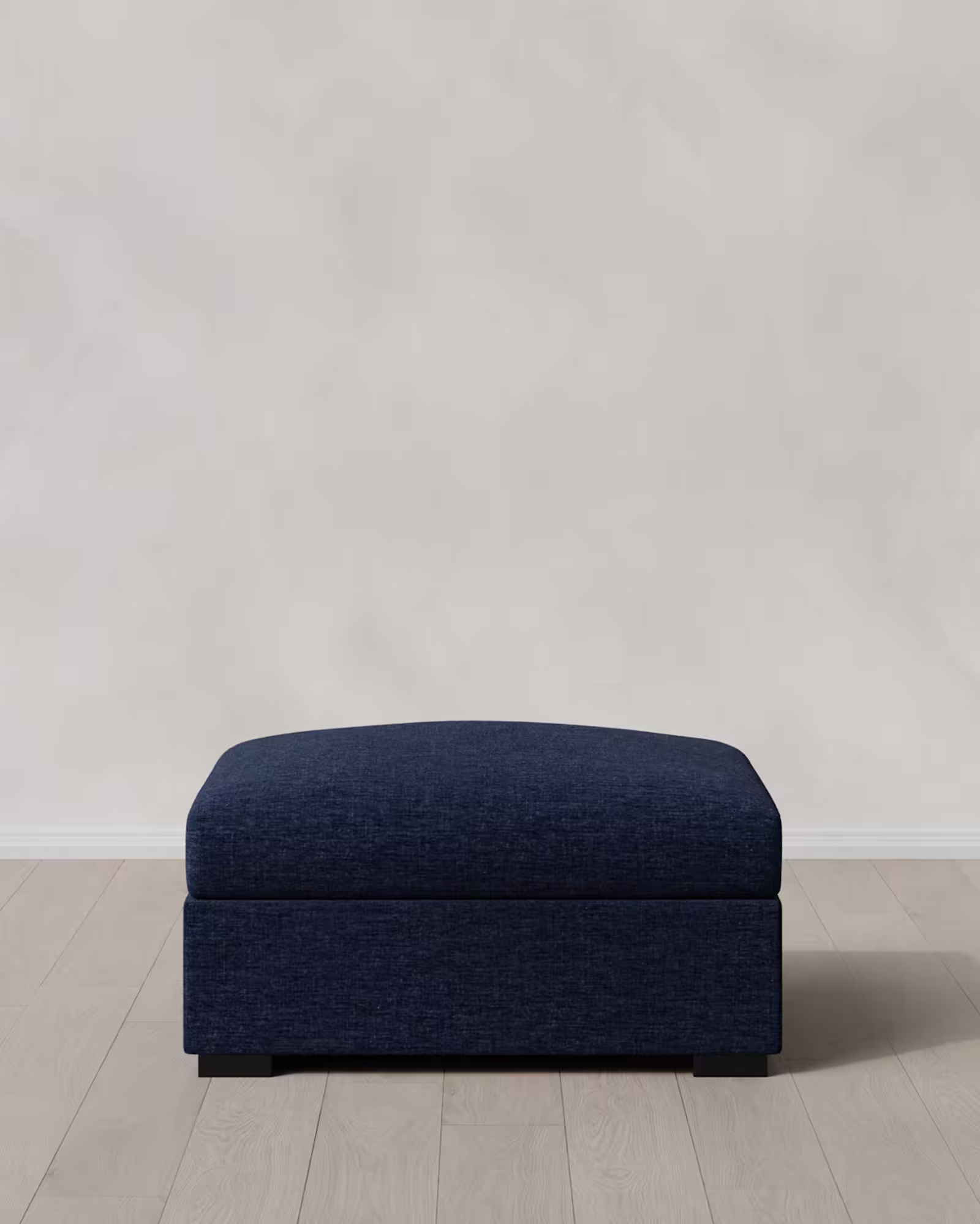 Dark blue ottoman on a light wooden floor.